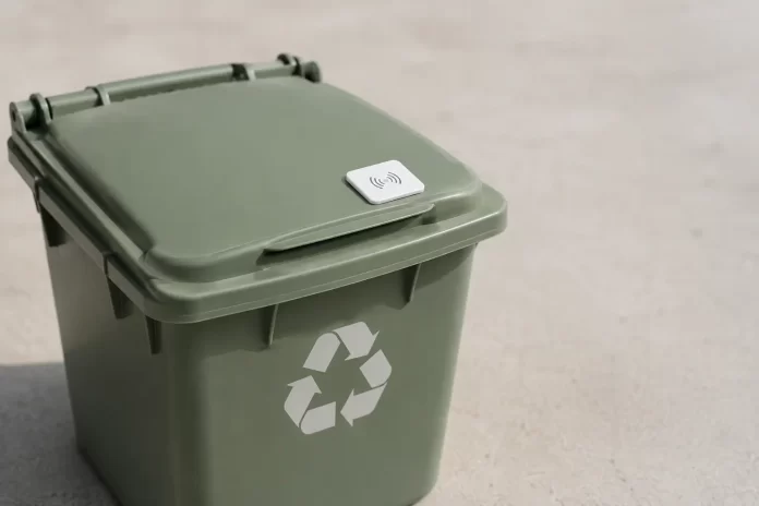 Bidone verde della raccolta differenziata con sensore RFID, simbolo della tariffa puntuale nei comuni rifiuti free italiani.