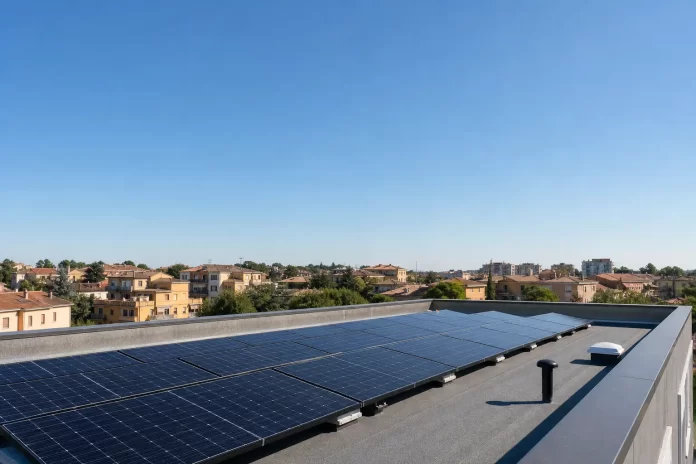 Pannelli fotovoltaici sul tetto di un condominio in una via cittadina, sotto il sole